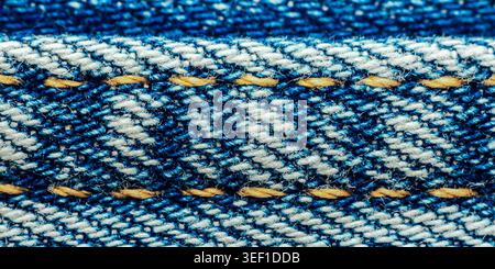 Nahaufnahme mit Textil-Hintergrund mit starkem blauem Denim-Gewebe und kontrastierenden gelben Garnen, perfekt für Modesthemen. Thailand-Fotografie, kein Gen Stockfoto