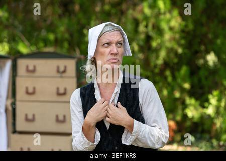 Frau in Vintage-Kleidung, die draußen mit einem nachdenklichen, skeptischen Gesichtsausdruck reagiert Stockfoto