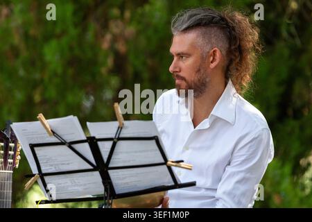 Ein Musiker spielt eine Akustikgitarre während einer Aufführung im Freien Stockfoto