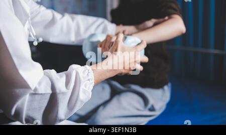 Alte Frauenausbildung bei Physiotherapeutin mit Kurzhanteln zu Hause. Therapeutin, die Seniorin bei Übungen im Pflegeheim unterstützt. Usin bei älteren Patienten Stockfoto