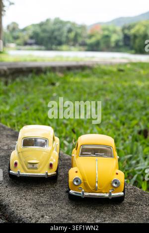 CHIANG Mai, THAILAND - 13. MAI 2026: Eine vertikale Hochwinkelaufnahme von zwei gelben Volkswagen Beetle Miniaturmodellen, einer matten und einer glänzenden Finis Stockfoto