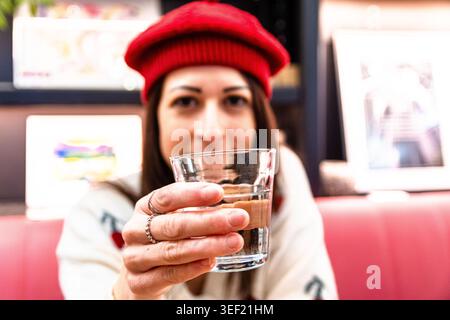 Frau, die allein reist und Wasserglas im Café anbietet Stockfoto