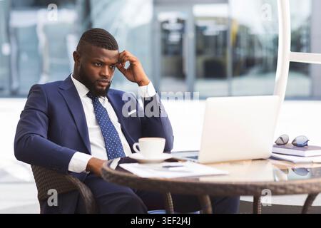 Geschäftsmann Von Laptop Liest Nachrichten Über Krise Im Café Stockfoto