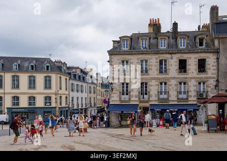 Vannes, Frankreich. 19. August 2025: Menschen gehen über einen belebten Platz, umgeben von historischen Gebäuden im Zentrum von Vannes, Bretagne. Stockfoto