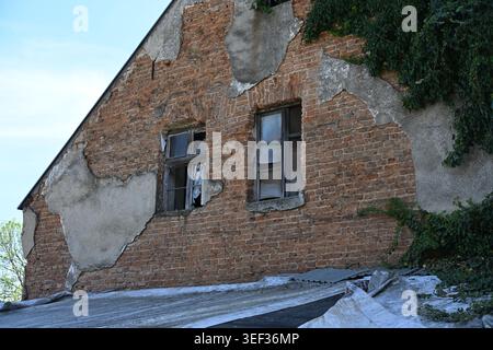 Altes baufälliges Landhaus mit freiliegenden Ziegelwänden und kaputten Holzfenstern Stockfoto