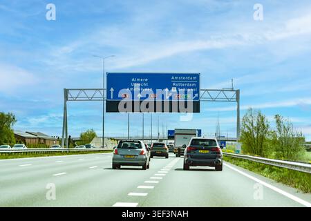 Niederlande - 17. April 2026: Verkehr auf der Autobahn A9, die sich einer großen Kreuzung nähert, mit Beschilderung nach Almere, Utrecht, Amstelveen, Amsterdam, R. Stockfoto
