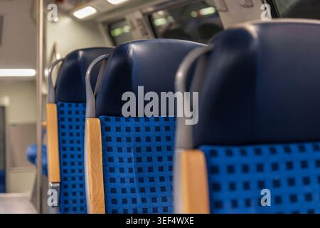 Nahaufnahme der blauen Kopfstützen des Sitzes in einer Zugkabine. Modernes Design der Passagiersitze. Stockfoto