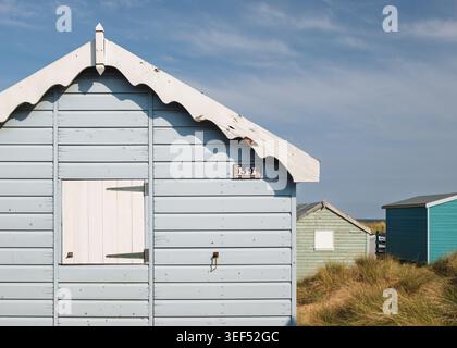 Vorderer Winkel eines weiß lackierten Chalets aus Holz am Strand mit geschlossenen Fensterläden in Hunstanton, Norfolk, England Stockfoto
