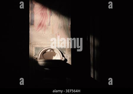 Florenz, Italien: Sunbeam beleuchtet das antike Fresko und das Steinbecken im Inneren der Kirche San Miniato al Monte. Moody religiöse Renaissance Wandgemälde. Stockfoto