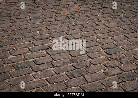 Nahaufnahme eines Hintergrunds aus Stein. Kopfsteinpflaster-Pflasterhintergrund. Strukturierter Hintergrund der Kopfsteinpflasterstraße. Backsteinstraße Hintergrund. Stockfoto