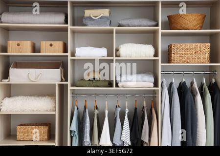 Kleiderschrank mit verschiedenen stylischen Kleidungsstücken, Accessoires und Wohnaccessoires im Innenbereich Stockfoto