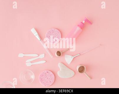 Trendiges Hautpflegekonzept mit Reinigungswerkzeugen, Kosmetikaccessoires und Essentials für das Spa auf pastellrosa Hintergrund. Hautpflege- und Schönheitskonzept. Stockfoto