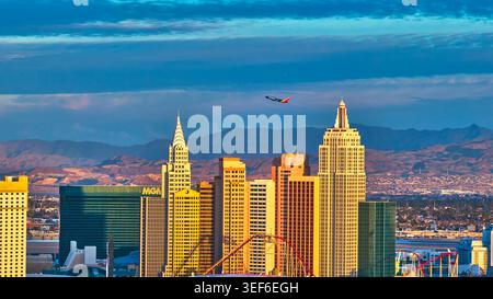 Skyline des Las Vegas South Strip mit New York New York und Flugzeug bei Sonnenuntergang Stockfoto