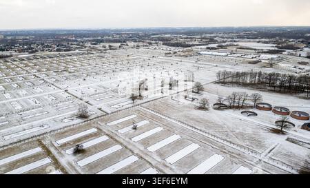 Ein Blick aus der Höhe der Drohne fängt die riesige verschneite Weite des Lagers Birkenau ein. Die Landschaft zeigt rechteckige Fußabdrücke zerstörter Kasernen, die stehen Stockfoto