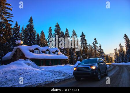 Winter Cabin Road und Sunrise Drive in Snowy Pine Forest Alberta Stockfoto