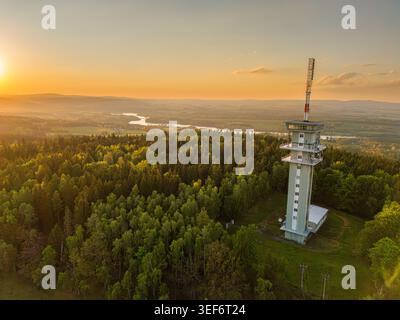 Kommunikationsturm über üppigem Wald bei Sonnenuntergang über rollende Landschaft und gewundenen Fluss. Zelena Hora Sender Stockfoto
