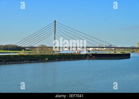 Moderne Kabelbrücke über einen breiten Fluss in Industrielandschaft Stockfoto
