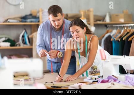 Modedesigner entwickeln Kleidungsmuster auf Papier im Studio Stockfoto