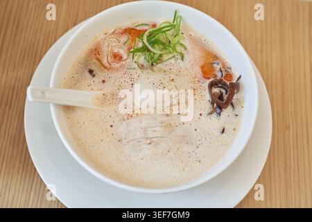 Cremige Tori Paitan Ramen mit schaumiger Hühnerbrühe, weichgekochtem Ei, zartem Hühnerchashu und frischen Nudeln, die appetitlich gefangen werden, helles Licht. Stockfoto
