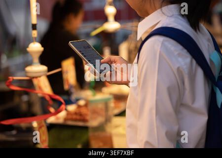 Frau, die ein Smartphone im Markt, im Reisestil und im digitalen Verhalten nutzt, Nahaufnahme. Stockfoto
