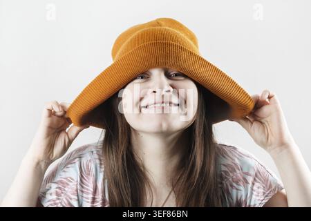 Glückliche, fröhliche Hipster-Frau in Strickmütze Stockfoto