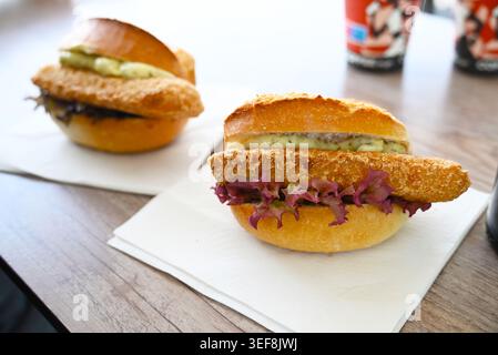 Zwei knusprige Fischbrötchen serviert auf weißen Servietten in einem Restaurant in Hamburg. Die Sandwiches sind mit paniertem Fisch gefüllt Stockfoto