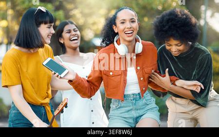 Frauen, Freunde und lachen mit dem Telefon für Witze, Bindungen und Zugehörigkeit zur Gruppe. Weibliche Menschen, glücklich und zusammen mit Vielfalt, Schwesternschaft und Stockfoto