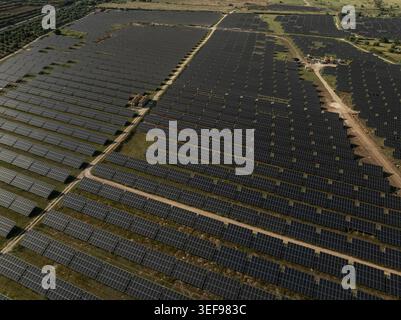 Luftaufnahme eines riesigen Solarpaneels und einer Photovoltaik-Farm, die sich über grüne Felder unter hellem Tageslicht in Priolo Gargallo, Sizilien, Italien erstreckt. Stockfoto