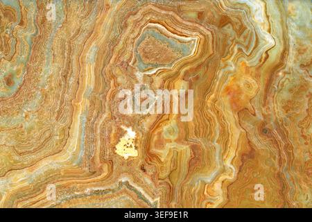 Onyx-Marmorstein, gekreuzt. Die Hauptfarben sind Braun und Grün.Textur und Hintergrund. Stockfoto