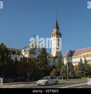 Targu Mures, Rumänien - 17. oktober 2025. Der ikonische Kulturpalast und der Turm des Alten Rathauses von Targu Mures, Rumänien, stehen entlang einer belebten Straße Stockfoto