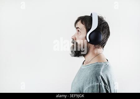 Seitenansicht eines bärtigen Mannes, der Musik über Kopfhörer hört Stockfoto