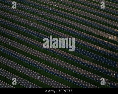 Luftaufnahme von Reihen von Solarpaneelen, die auf grünen Feldern für die Erzeugung erneuerbarer Energien in Augusta, Sizilien, Italien installiert sind. Stockfoto