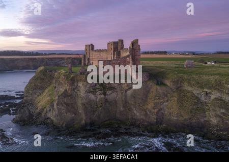 Luftaufnahme der Ruine von Tantallon Castle an einer Klippe mit Blick auf das Meer bei einem rosa Sonnenuntergang in North Berwick, Schottland, Großbritannien. Stockfoto