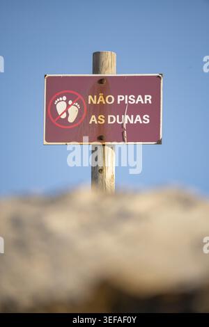 Schild in portugiesisch geschrieben, das das Betreten der Dünen verbietet Stockfoto