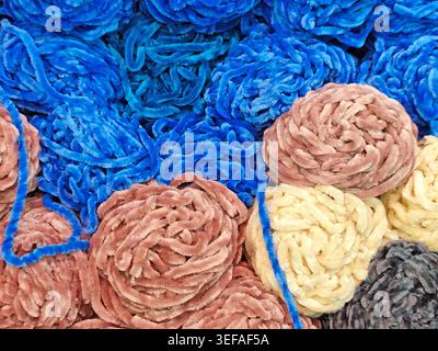 Nahaufnahme von mehrfarbigen Garnbällen, zusammengestapelt, weiche Faserstruktur, Strickmaterial, Vollformathintergrund Stockfoto