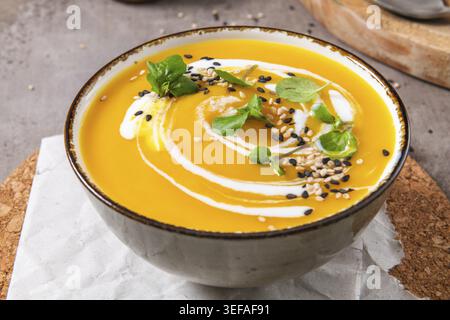 Köstliche hausgemachte Kürbissuppe mit Sahne mit Sesamsamen und Brunnenkresse Stockfoto