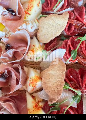 Buntes Fingerfood-Sortiment mit offenen Sandwiches, Fleischgerichten, Meeresfrüchten und frischem Gemüse für Buffet- oder Luxusveranstaltungen Stockfoto