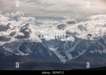 Verschneite Berggipfel und Gletscher unter dramatischen Wolken Stockfoto
