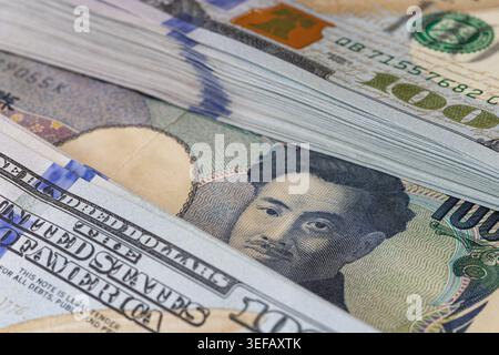 Japanische Yen-Banknotenporträt unter einem Stapel von US-Dollar-Scheinen Stockfoto