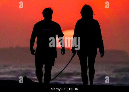 Isle Of Palms, Usa. Mai 2026. Ein Paar mit einer Silhouette vom Sonnenaufgang über dem Atlantik an einem trüben Morgen am Front Beach, 14. Mai 2026 in Isle of Palms, South Carolina.Credit: Richard Ellis/Richard Ellis/Alamy Live News Stockfoto