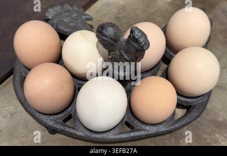 Frische Eier in einem gusseisernen Halter auf der Küchenzeile. Das Konzept der Ernährung und des Betriebs. Stockfoto