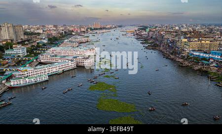 Luftaufnahme mit Booten und Gebäuden entlang des Buriganga River in Dhaka bei Sonnenuntergang in Bangladesch Stockfoto