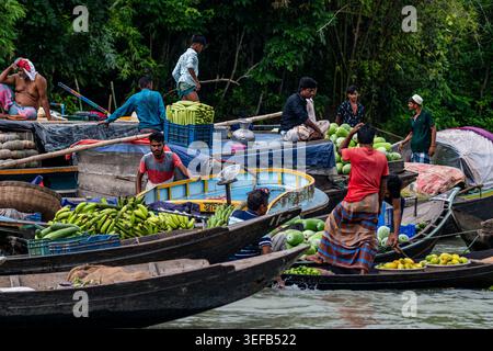 Geschäftiger schwimmender Markt mit Händlern, die bei Tageslicht in den Wasserkanälen von Barishal, Bangladesch, Obst und Gemüse verkaufen Stockfoto