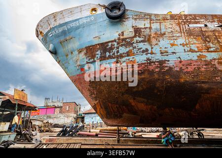 Männer reparieren ein Boot in einer Schiffswrack-Werft in Dhaka, Bangladesch an einem bewölkten Arbeitstag Stockfoto
