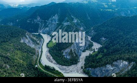 Aus der Vogelperspektive sehen Sie die Kurven der Rheinschlucht in der Schweiz, umgeben von grünen Hügeln und Felsformationen Stockfoto