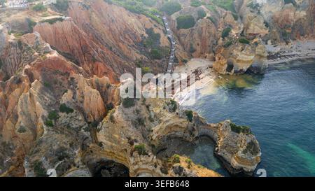 Blick auf die Strandklippen am Meer in der Algarve Portugal mit Felsformationen und ruhigem Wasser bei Sonnenuntergang Stockfoto