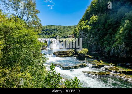 Der Strbacki Buk Wasserfall fließt an einem sonnigen Tag durch den Una Nationalpark in Bosnien und Herzegowina Stockfoto