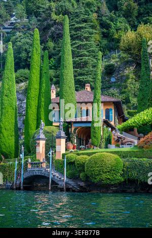 Zypressen umgeben eine Villa am Ufer des Comer Sees mit freiem Blick auf das Wasser in Italien Stockfoto