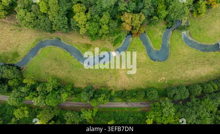 Der sich schlängelnde Fluss schlängelt sich durch üppiges Grün in der Nähe der Abtei von Fontenay in Frankreich Stockfoto