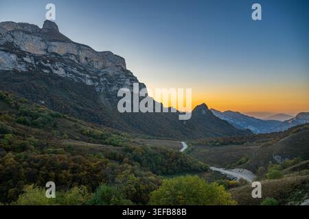 Abgelegene Berglandschaft mit einer gewundenen Straße bei Sonnenuntergang in Tschetschenien, Russland Stockfoto